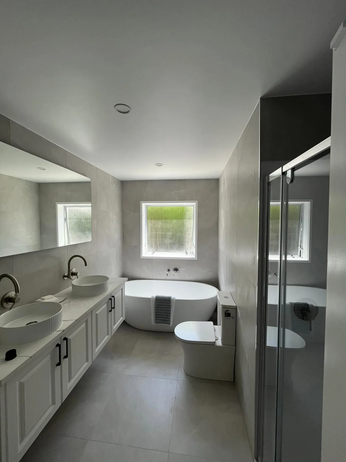 Completed bathroom renovation with a freestanding bath and double vanity